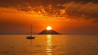Tramonto sul cratere dello Stromboli visto dalla Costa degli Dei con il cielo tinto di arancio e rosso sul mare Tirreno